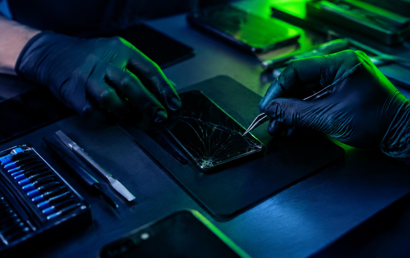 Technician repairing a cracked phone screen